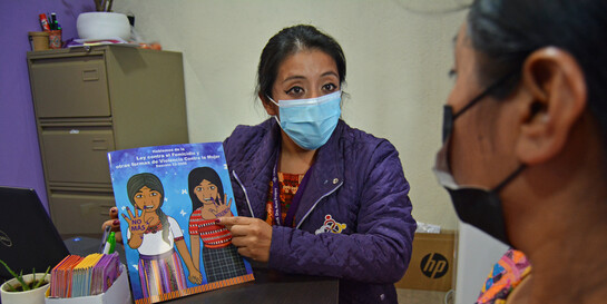 Eine Helferin in Guatemala klärt eine Frau über Gewaltprävention auf