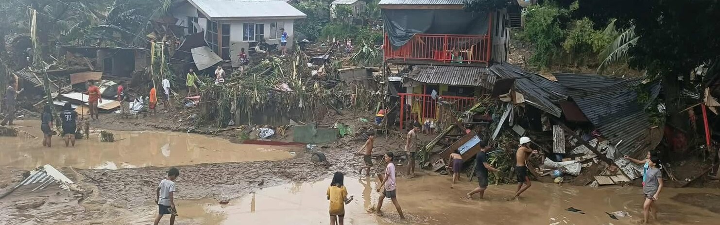 Menschen stehen auf den Philippinen vor zerstörten Häusern und auf überfluteten Straßen Menschen stehen auf den Philippinen vor zerstörten Häusern und auf überfluteten Straßen