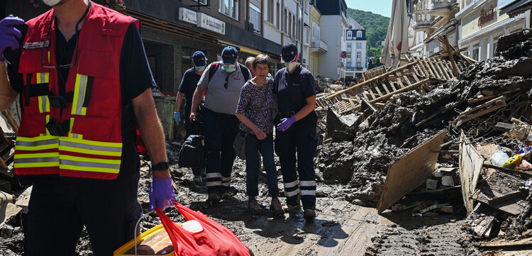 Einsatzkräfte der Johanniter helfen einer Frau im Hochwassergebiet Einsatzkräfte der Johanniter helfen einer Frau im Hochwassergebiet