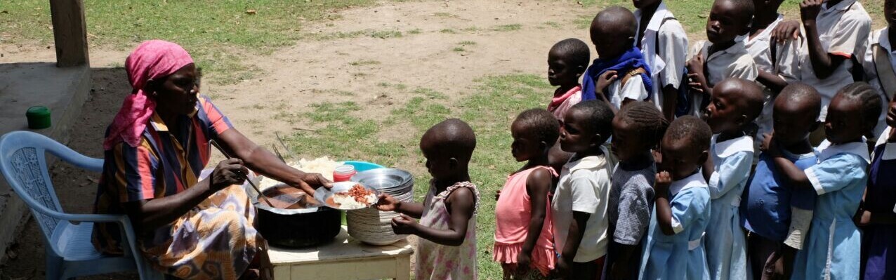 In einer Schule in Afrika bekommen Kinder Schulessen ausgeteilt.