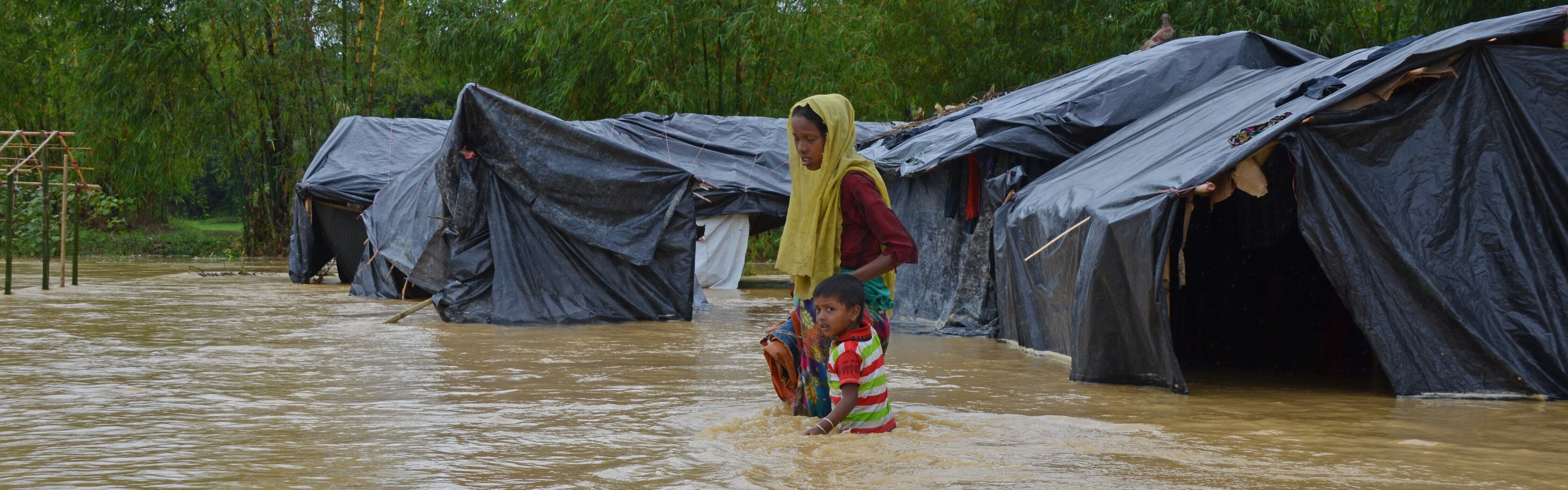 Frau & Kind inmitten eines überfluteten Flüchtlingscamps für Rohingya