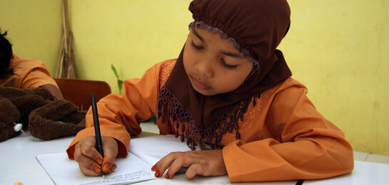 In Indonesien können viele Kinder nicht in die Schule gehen. Ein Mädchen lernt schreiben und lesen in der Grunschule.