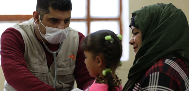 Ein Arzt hört ein Mädchen mit einem Stethoskop ab