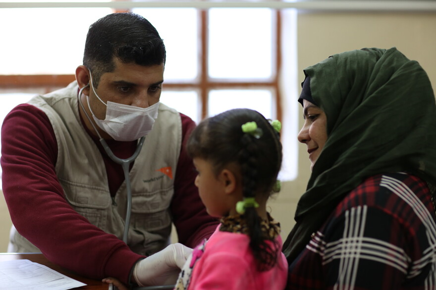 Ein Arzt hört ein Mädchen mit einem Stethoskop ab