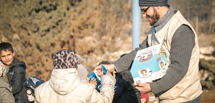 Ein Helfer von der Organisation Islamic Relief verteilt Süßigkeiten an Kinder, Archivbild Ein Helfer von der Organisation Islamic Relief verteilt Süßigkeiten an Kinder, Archivbild