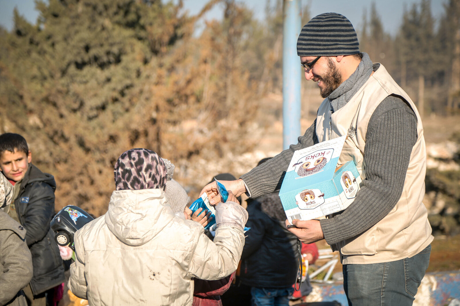 Ein Helfer von der Organisation Islamic Relief verteilt Süßigkeiten an Kinder, Archivbild