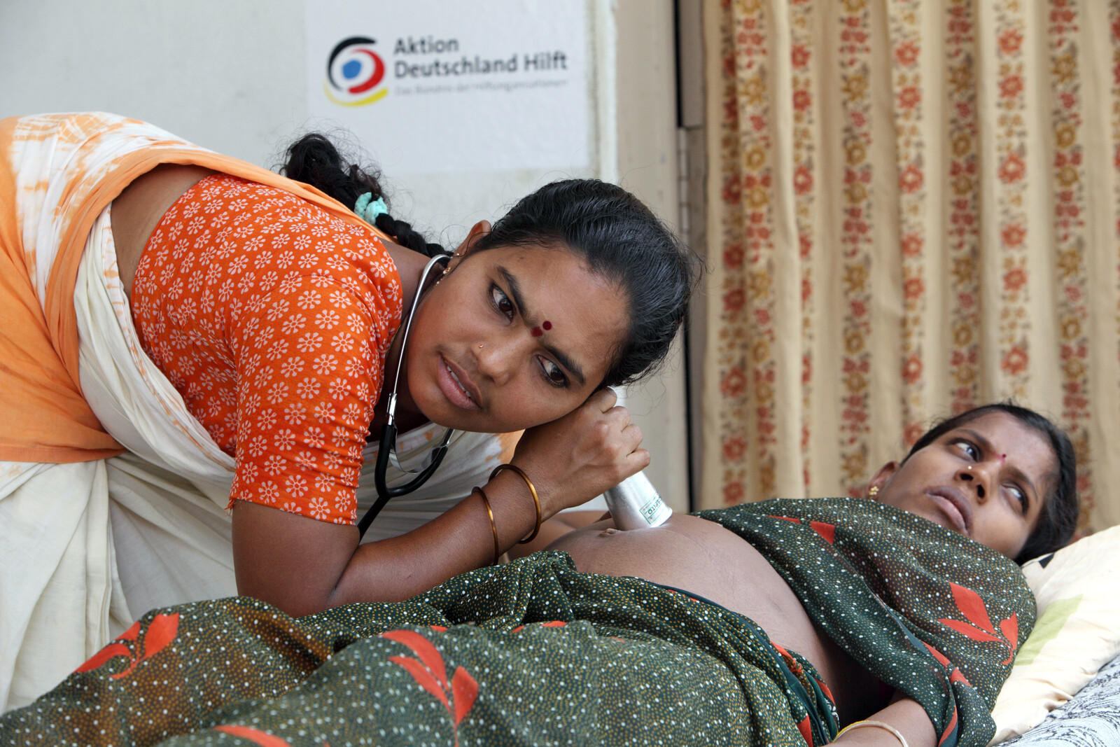 Eine Krankenschwester untersucht in einem indischen Krankenhaus den Bauch einer schwangeren Frau 