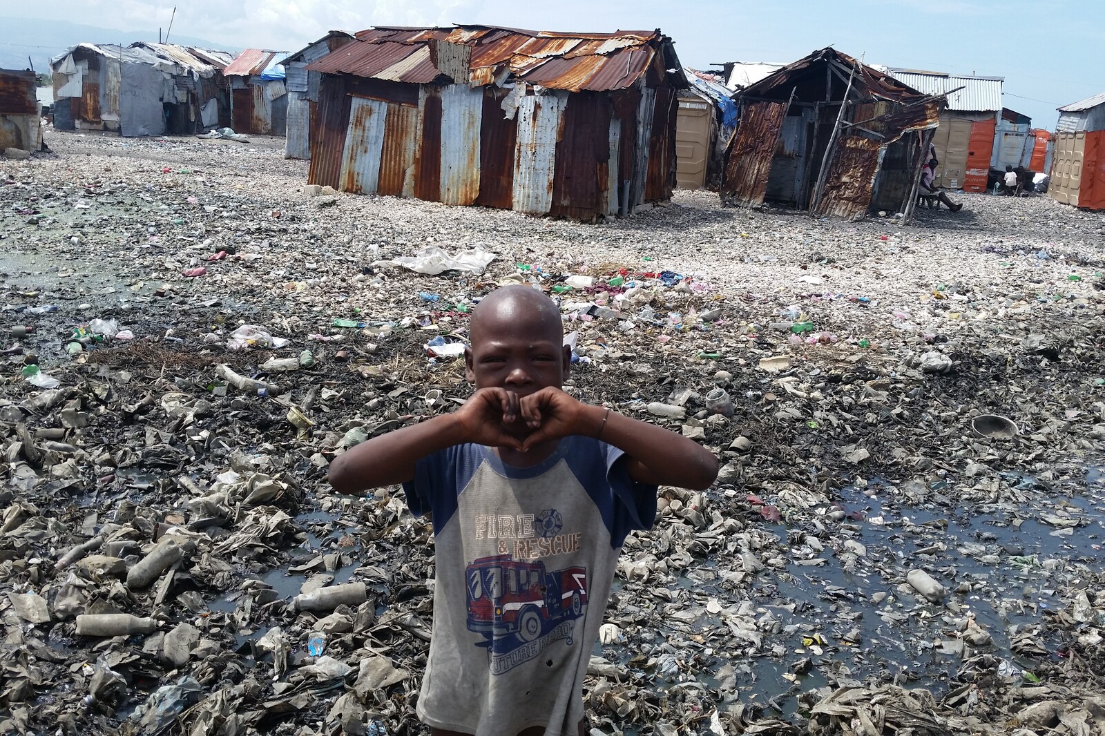 Ein Junge steht in einer Wellblechhüttensiedlung in einem der vielen Viertel Haitis, die von Armut und großer Not gezeichnet sind. Durch das schwere Erdbeben und den Hurrikan hat sich die Lage für viele weiter verschlimmert.