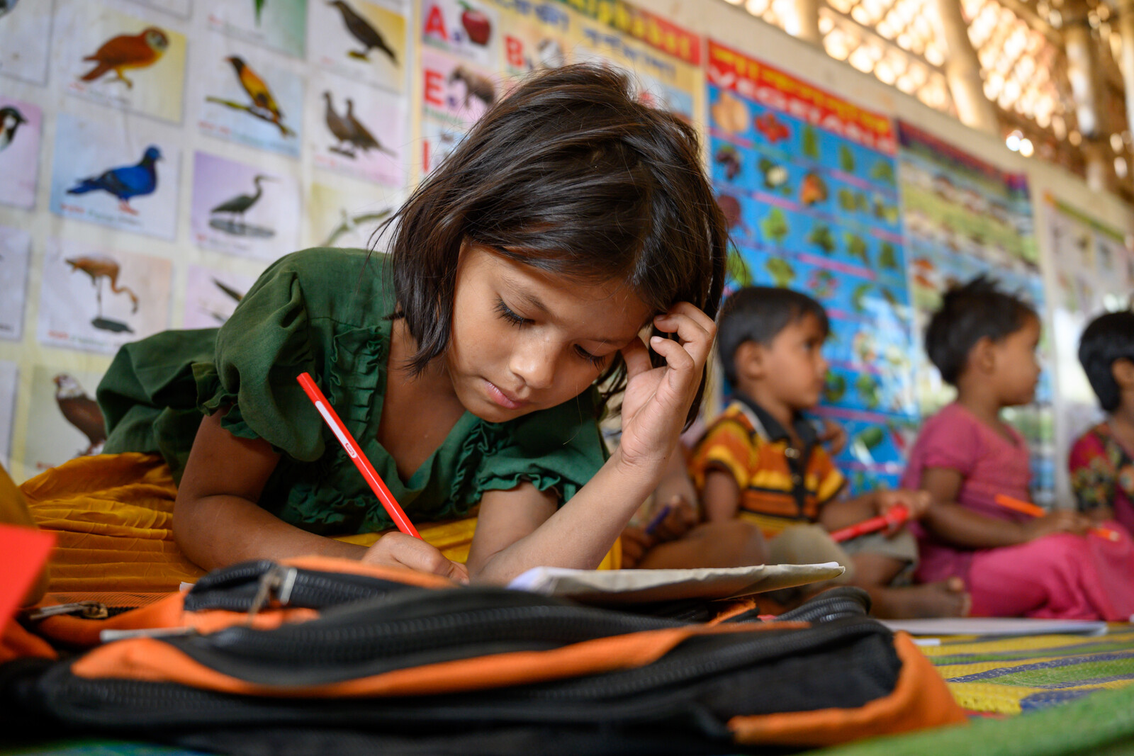 Ein Mädchen in einer Schule in Bangladesch löst Aufgaben in einem Buch