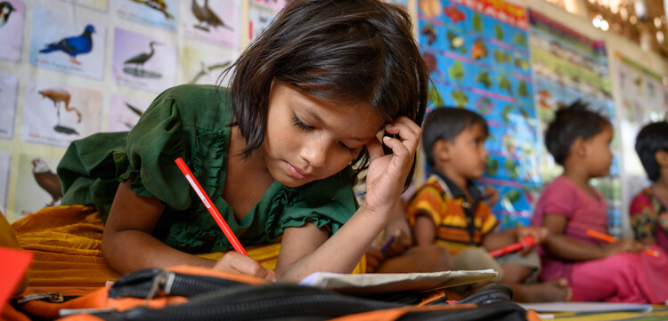 Ein Mädchen in einer Schule in Bangladesch löst Aufgaben in einem Buch Ein Mädchen in einer Schule in Bangladesch löst Aufgaben in einem Buch
