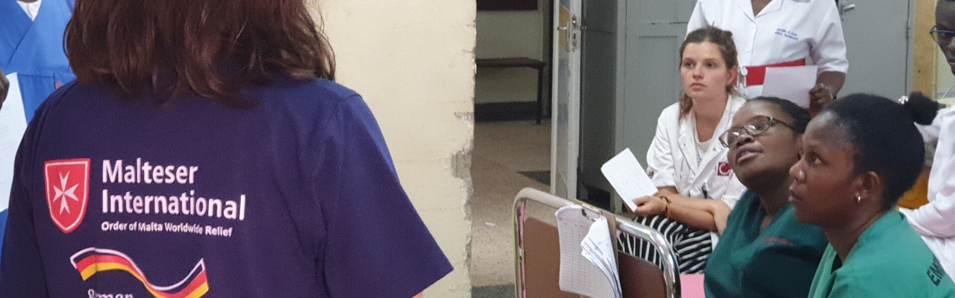 Helfer von Malteser International klären Krankenhausmitarbeiter in Uganda über Corona auf