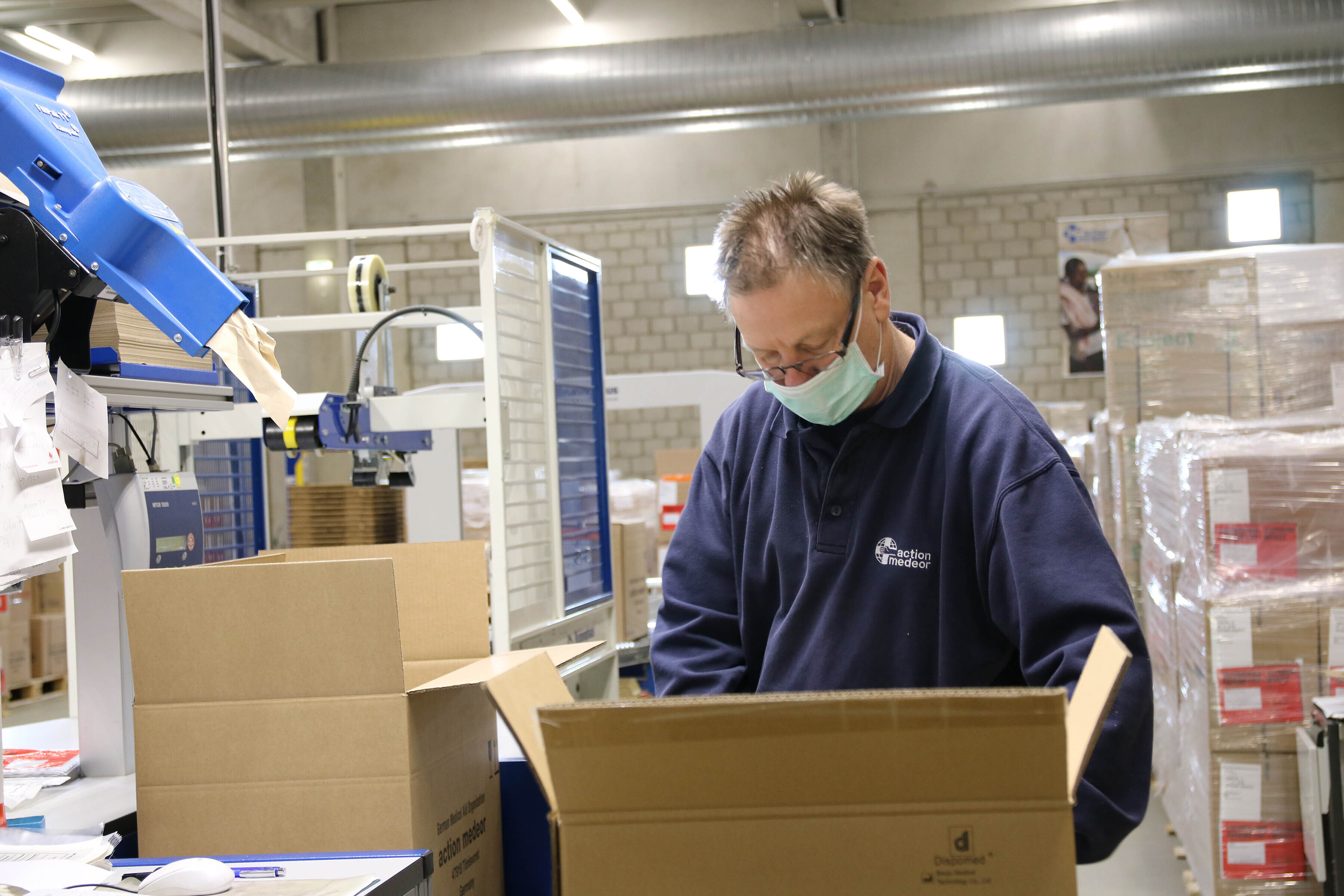 Ein Mitarbeiter von action medeor bei der Verpackung von Medikamenten Ein Mitarbeiter von action medeor bei der Verpackung von Medikamenten