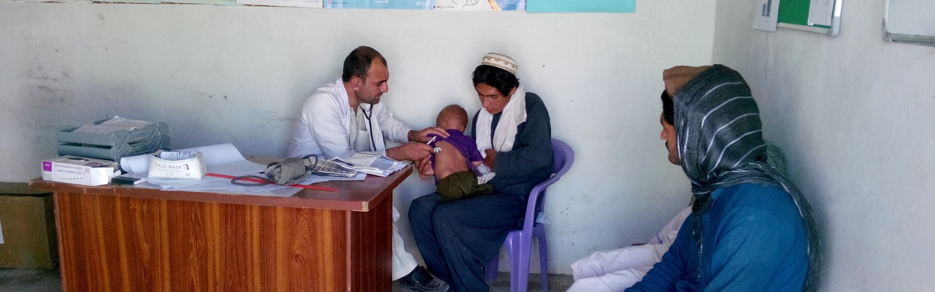 Ein Arzt untersucht in einer mobilen Gesundheitsstation einen kleinen Patienten.