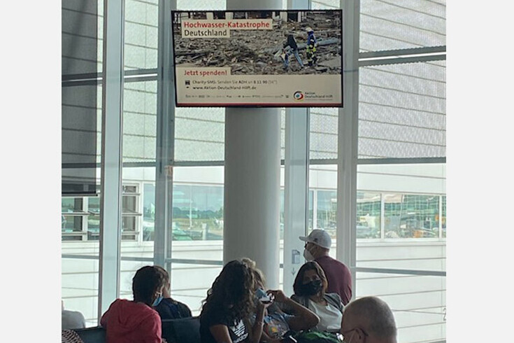 Cittadino schaltet im Boardingbereich eines Flughafens Werbung für Aktion Deutschland Hilft Cittadino schaltet im Boardingbereich eines Flughafens Werbung für Aktion Deutschland Hilft