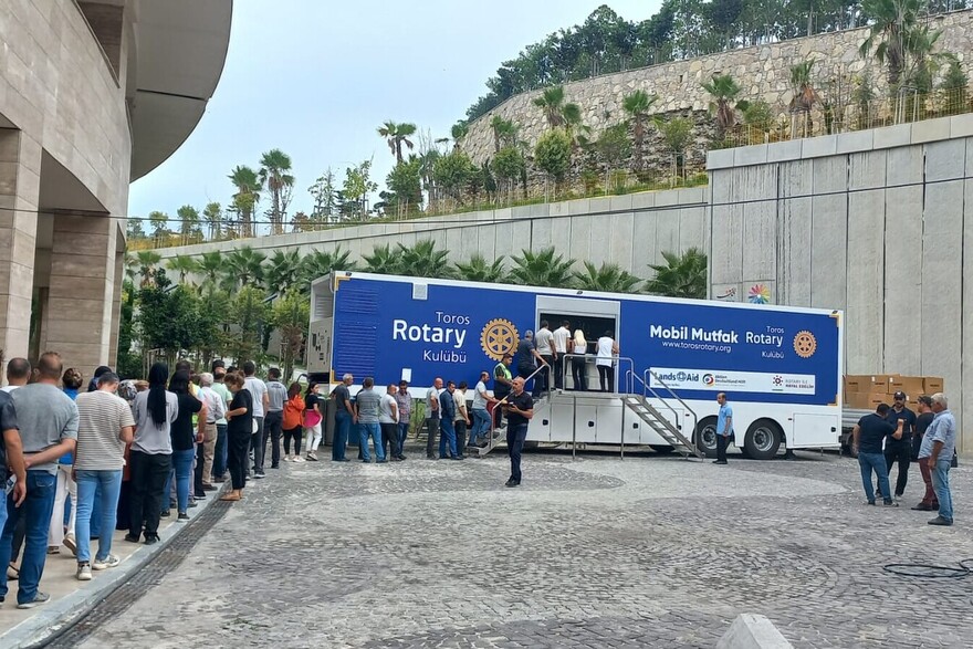 Viele Menschen stehen vor einem Foodtruck in der Türkei an, um sich mit notwendigen Lebensmitteln zu versorgen