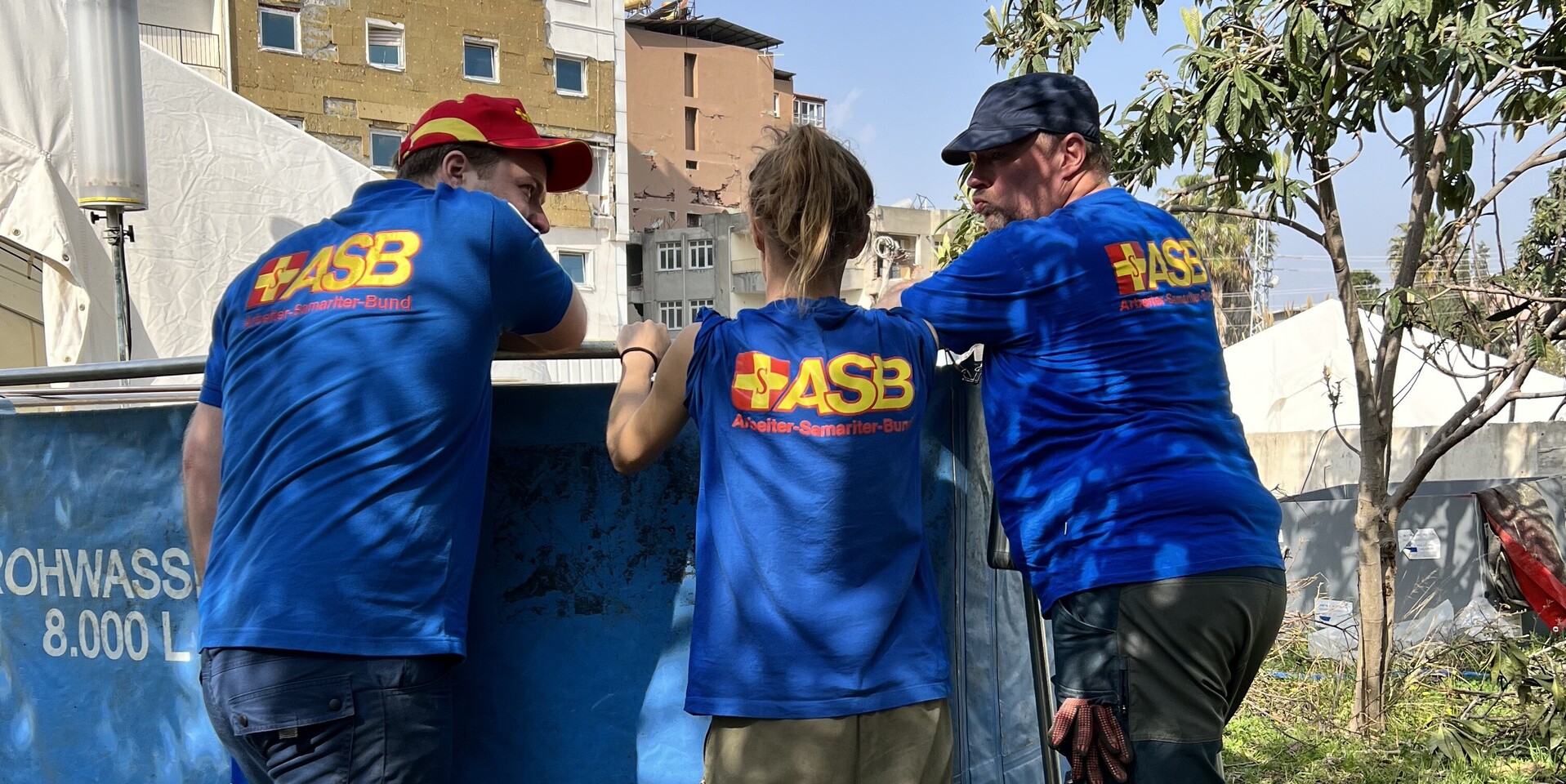 Helfer:innen des FAST-Teams an einem Wassertank Helfer:innen des FAST-Teams an einem Wassertank