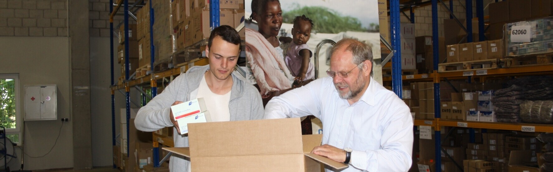 In einem Lager packen Bernd Pastors und ein Helfer Pakete für Flüchtlinge im Mittelmeer.