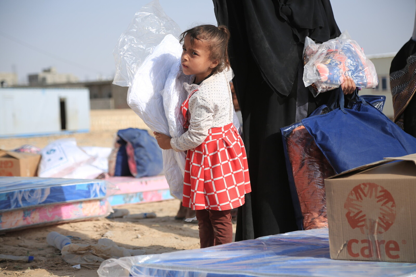 Ein Mädchen im Jemen mit Hilfsgütern von CARE
