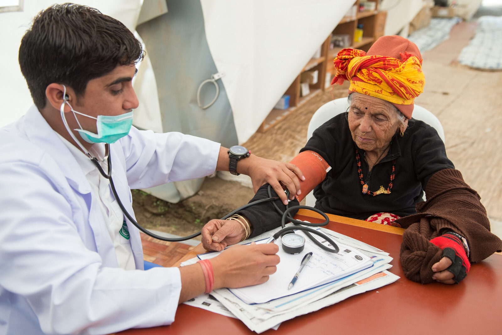 Ein Arzt in Nepal misst den Blutdruck einer Patientin 