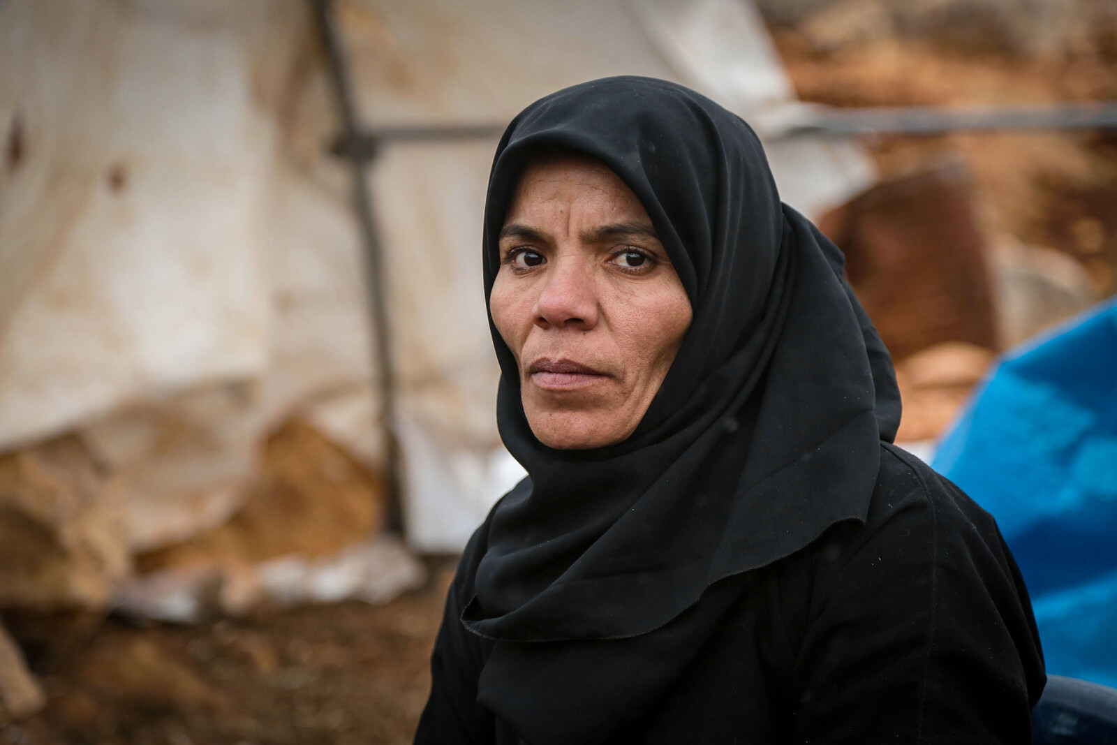 Eine Frau steht in den Trümmern von Aleppo