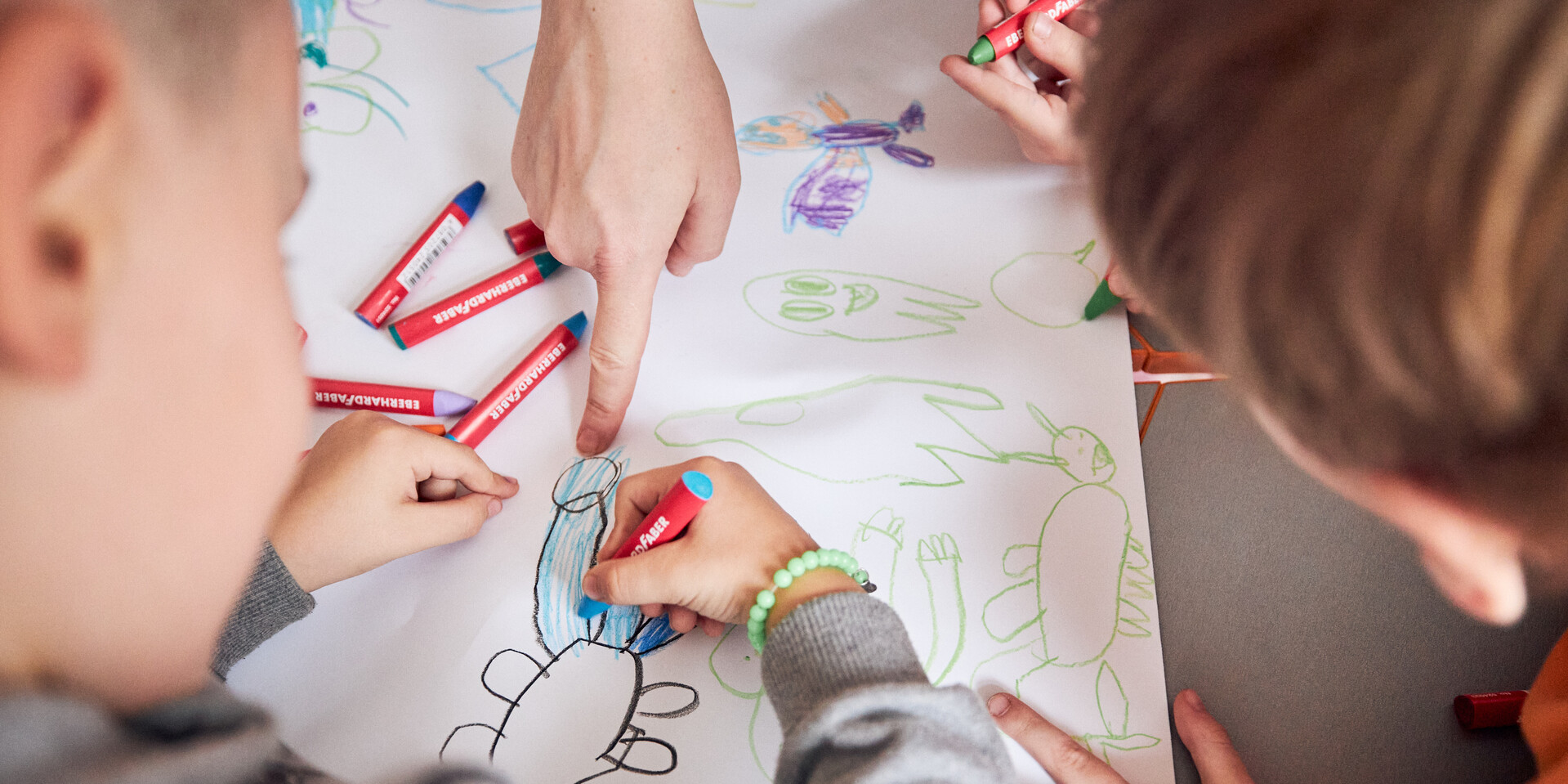 Kinder malen mit Fettstiften ein Bild