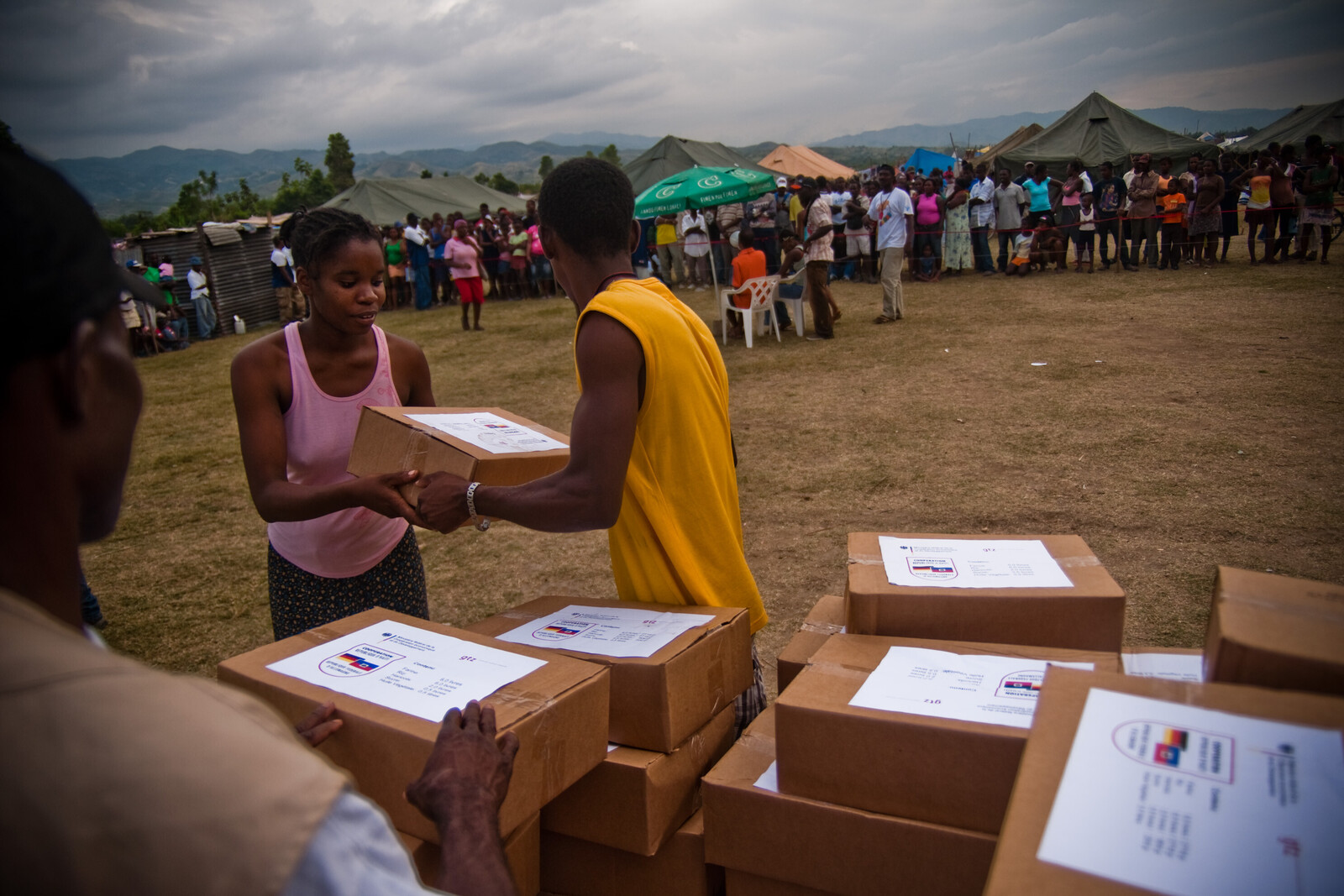 Nach dem Erdbeben in Haiti werden Hilfsgüter an die betroffene Bevölkerung verteilt. Eine Frau erhält Nahrungsmittel.