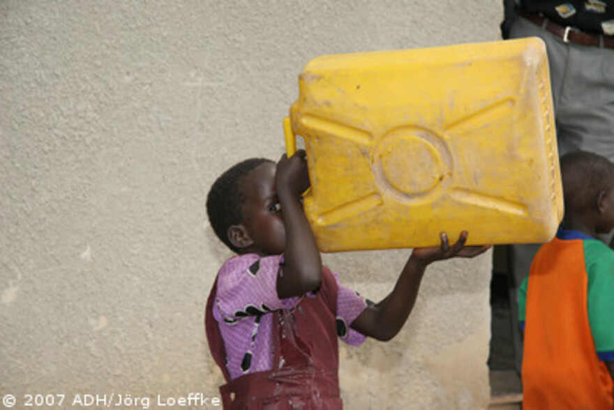 Flut Afrika: Kind trinkt aus Wasserkanister