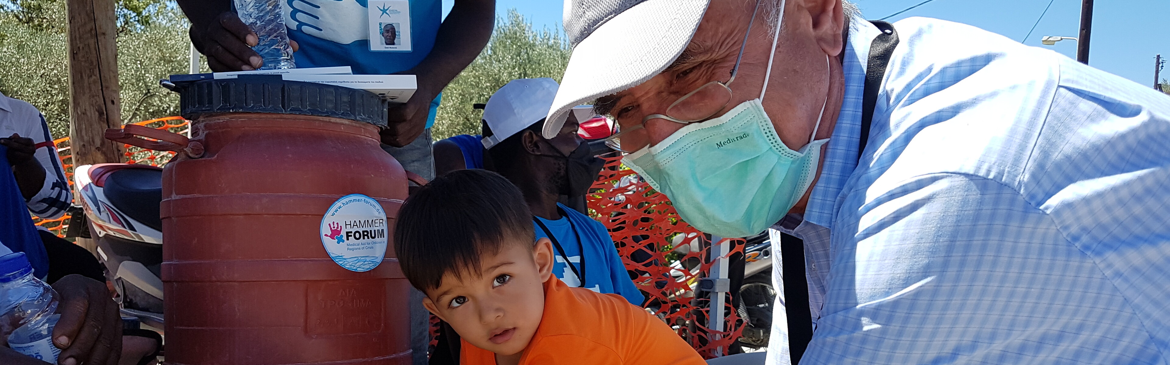 Ein Kind und ein Mann an einer Waschstelle