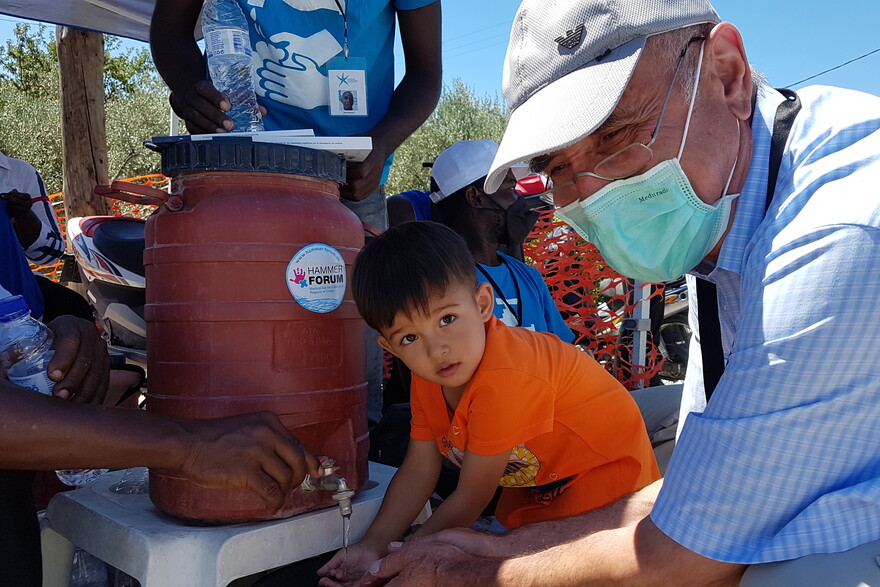 Ein Kind und ein Mann an einer Waschstelle