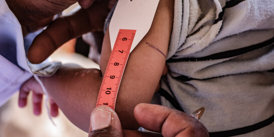 Einem Kind im Sudan wird der Oberarm mit einem Hungermaßband gemessen