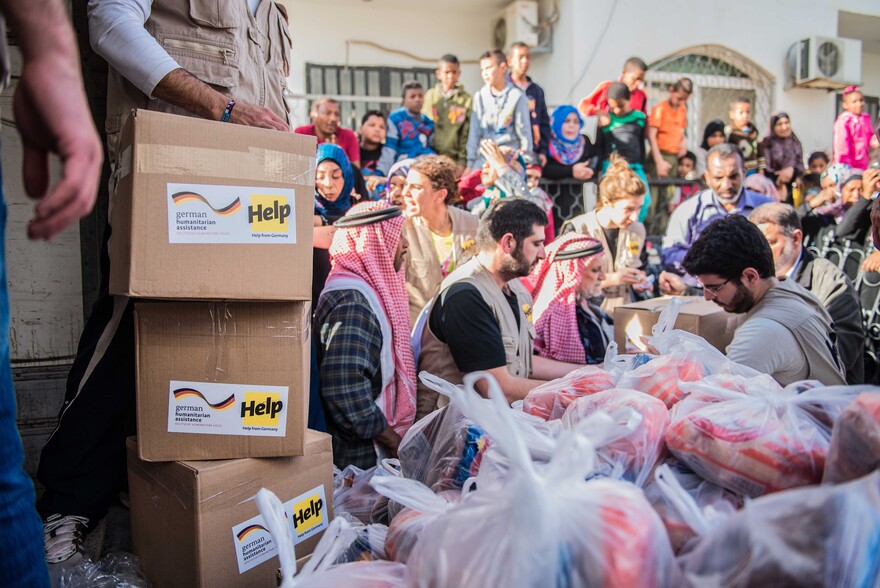 Helfer verteilen Hilfsgüter an Flüchtlinge. Helfer verteilen Hilfsgüter an Flüchtlinge.