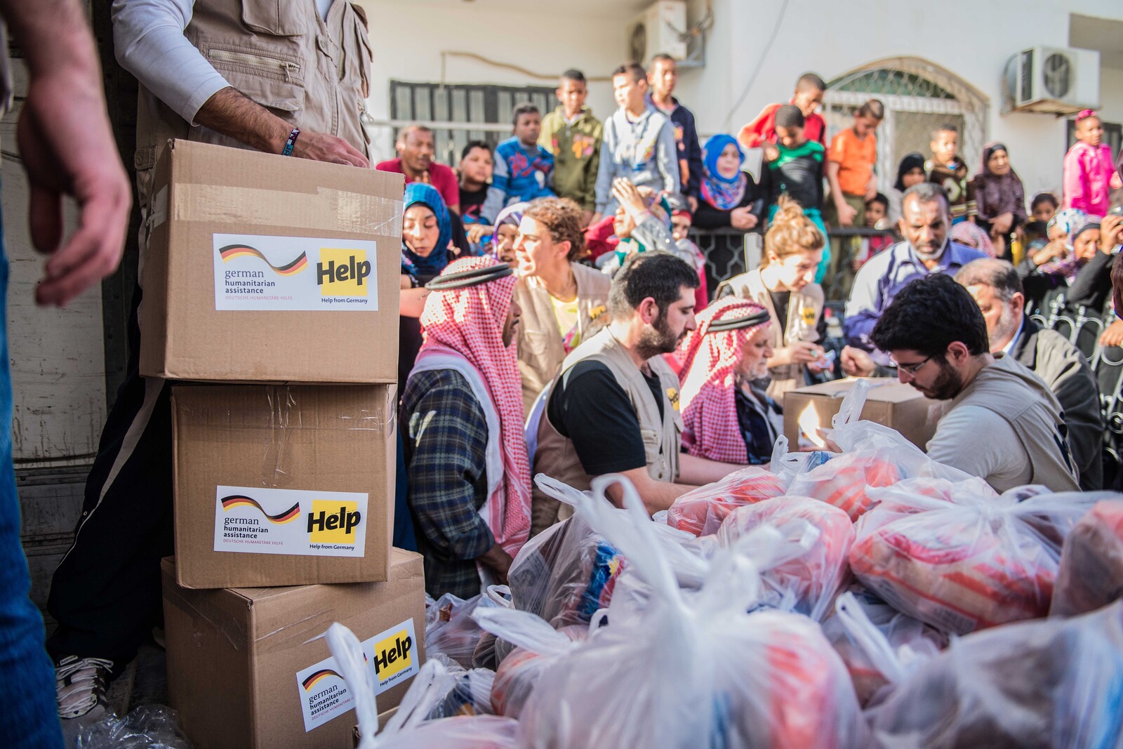 Helfer verteilen Hilfsgüter an Flüchtlinge