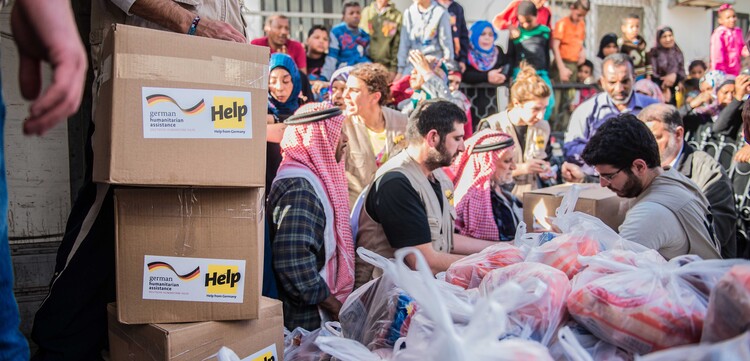 Helfer verteilen Hilfsgüter an Flüchtlinge Helfer verteilen Hilfsgüter an Flüchtlinge