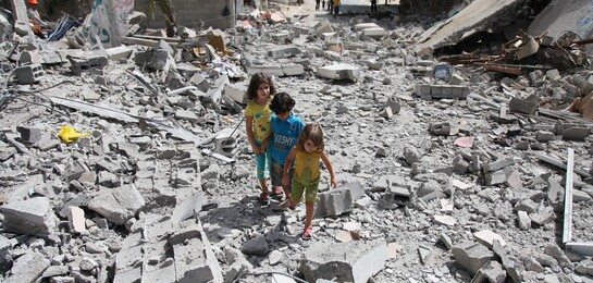 Flüchtlinge in Syrien: In einem von Krieg und Bomben betroffenen Gebiet stehen drei Kinder und schauen sich die Zerstörung an.