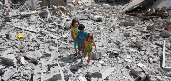 Flüchtlinge in Syrien: In einem von Krieg und Bomben betroffenen Gebiet stehen drei Kinder und schauen sich die Zerstörung an.