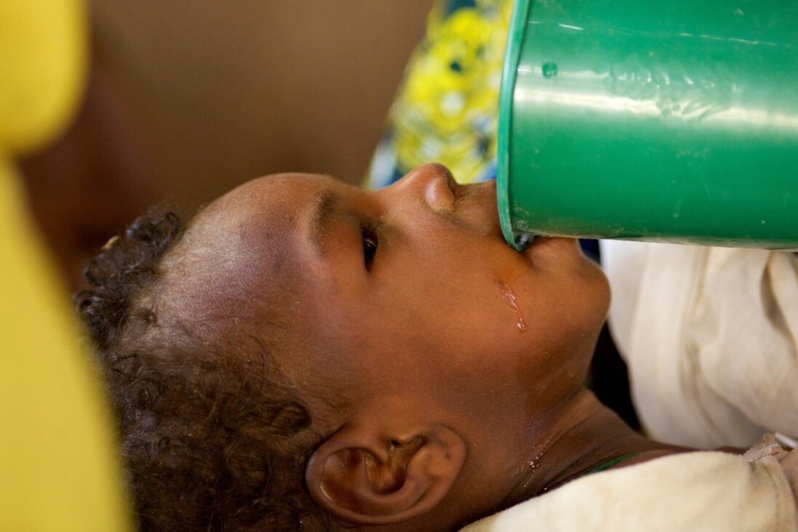 Ein Mädchen in Nigeria trinkt Wasser aus einem Becher (Archivbild) 