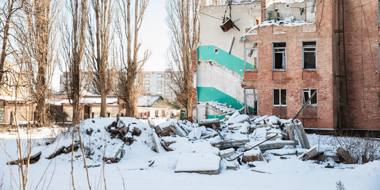 Ein zerstörtes Wohnhaus in der Ukraine umgeben von Schnee