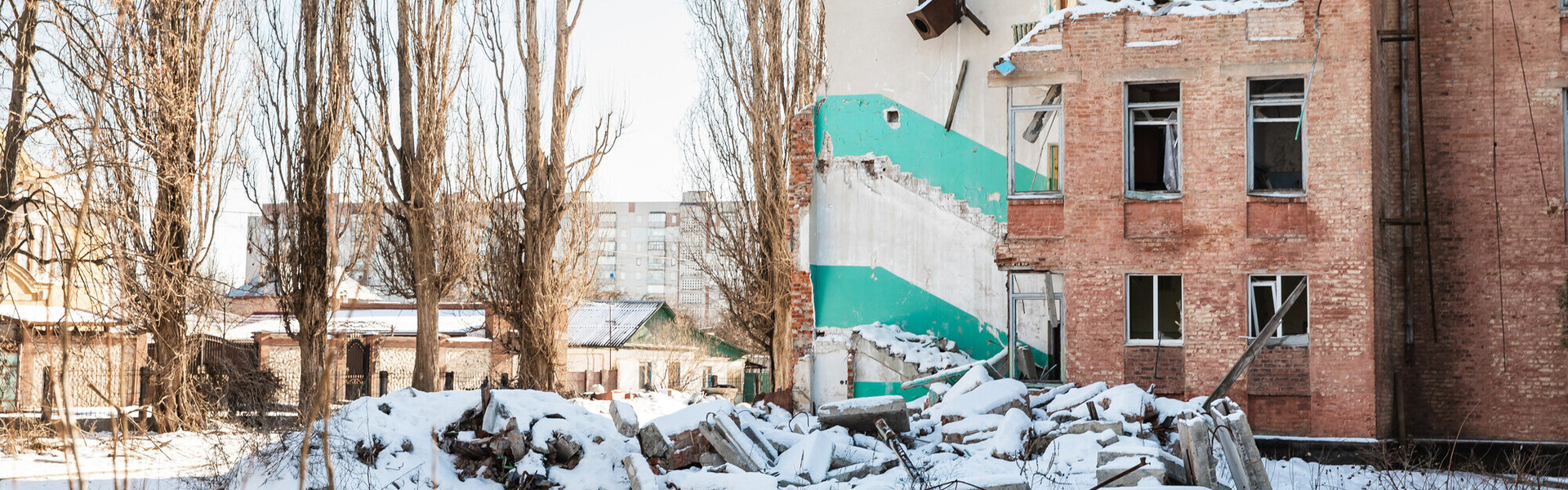 Ein zerstörtes Wohnhaus in der Ukraine umgeben von Schnee