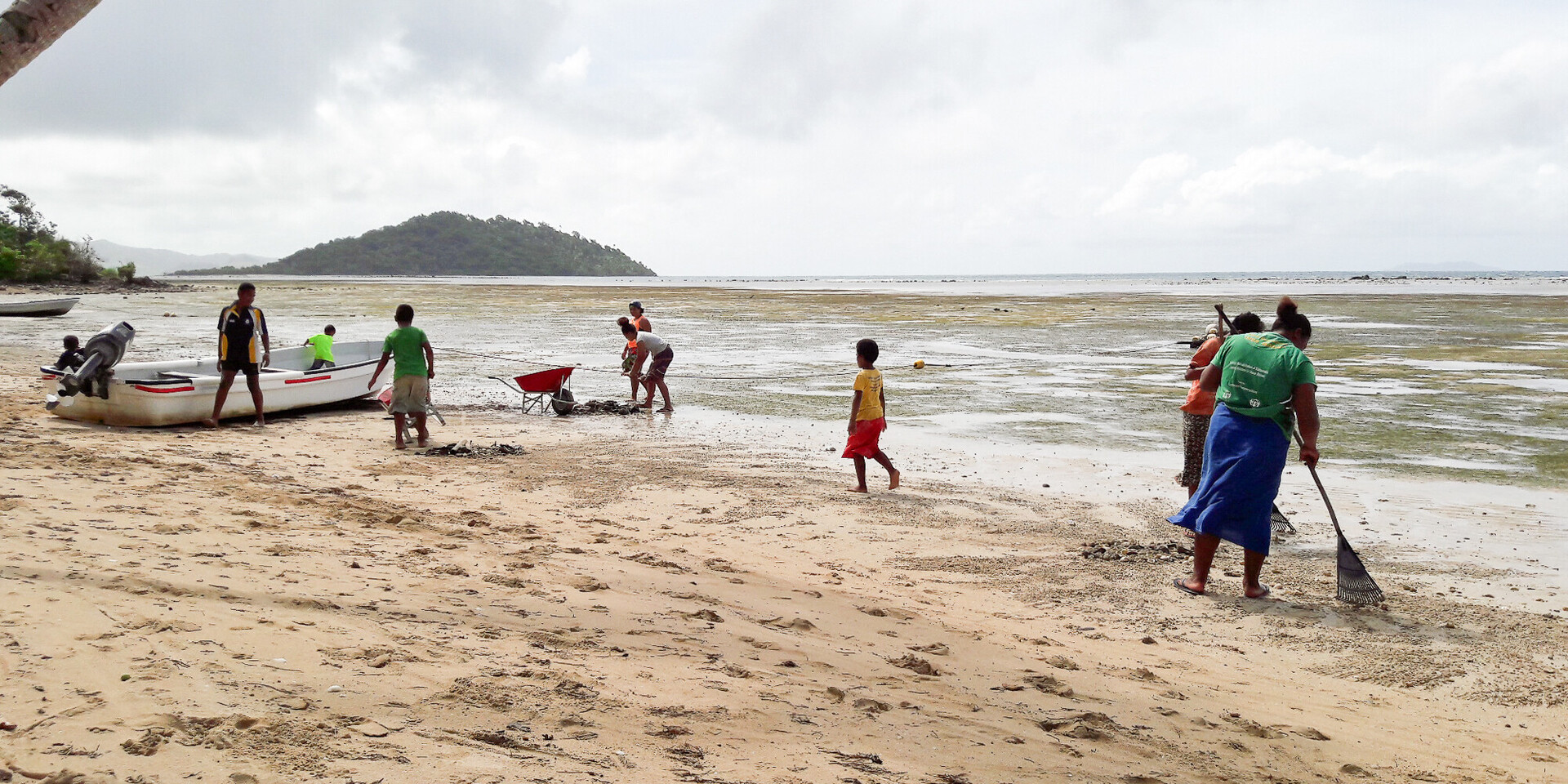 Menschen aus Fidschi, einem Land Ozeaniens, bei der Reinigung des Strandes