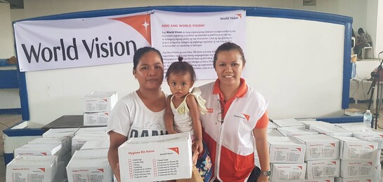 Mutter und Kind erhalten ein Hygiene-Kit von der Bündnisorganisation World Vision