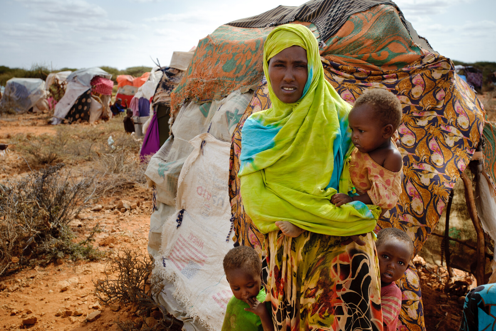 Eine Frau steht mit ihren Kindern in einem Flüchtlingslager in der nähe der somalischen Grenze.