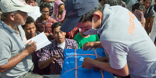 Helfer verteilen Hilfsgüter an die Menschen in Nepal