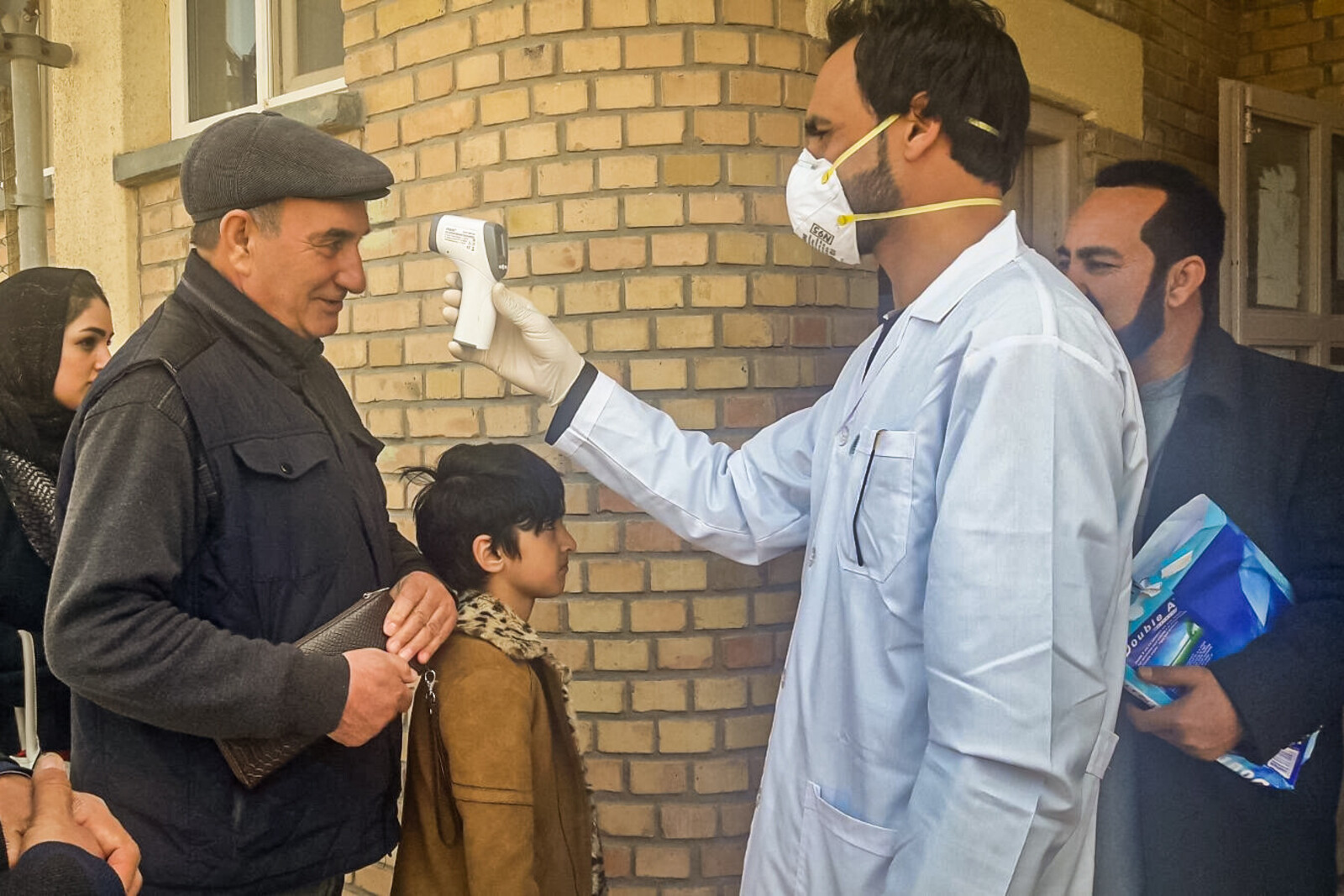 Corona-Nothilfe in Afghanistan: ein Arzt misst Fieber