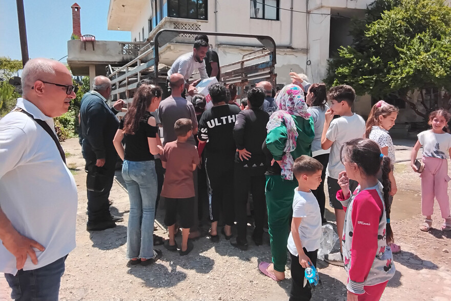 Ein Helfer verteilt Hilfsgüter in Syrien von einem Lastwagen