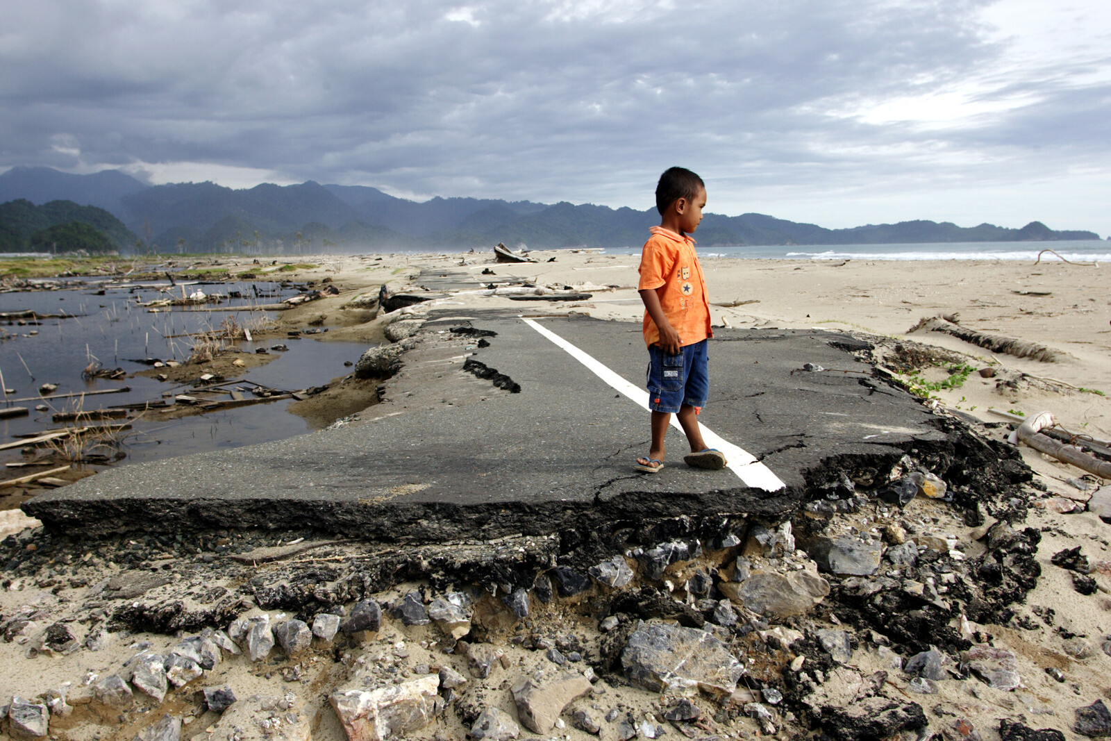 Auch 2004 traf Indonesien eine Naturkatastrophe: Ein Junge steht auf einer durch den Tsunami zerstörten Straße