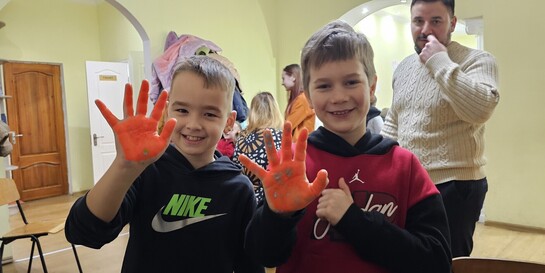 Kindernachmittag in Tschornomorsk: Kinder zeigen rot angemalte Hände in die Kamera