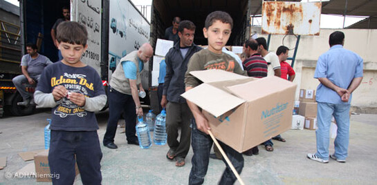 Syrische Jungen bekommen Hilfslieferungen