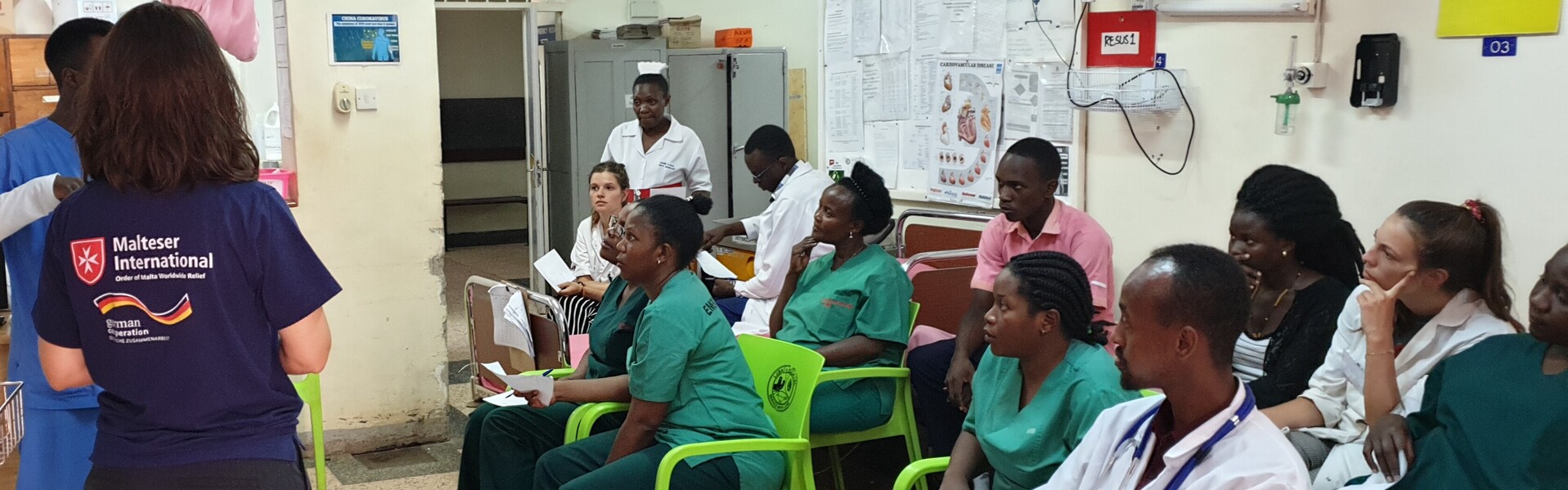 Helfer von Malteser International klären die Ärzte und Krankenschwestern über die Corona-Vorsorgemaßnahmen in einem Krankenhaus in Uganda auf