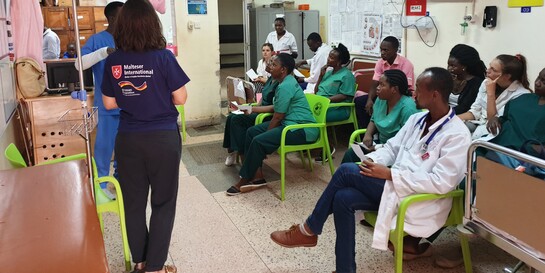 Helfer von Malteser International klären die Ärzte und Krankenschwestern über die Corona-Vorsorgemaßnahmen in einem Krankenhaus in Uganda auf