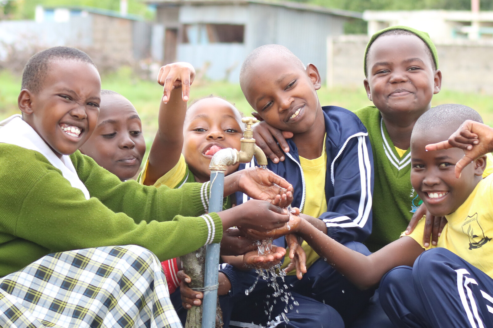 Schulkinder in Kenia freuen sich über sauberes Trinkwasser, das aus dem Brunnen kommt